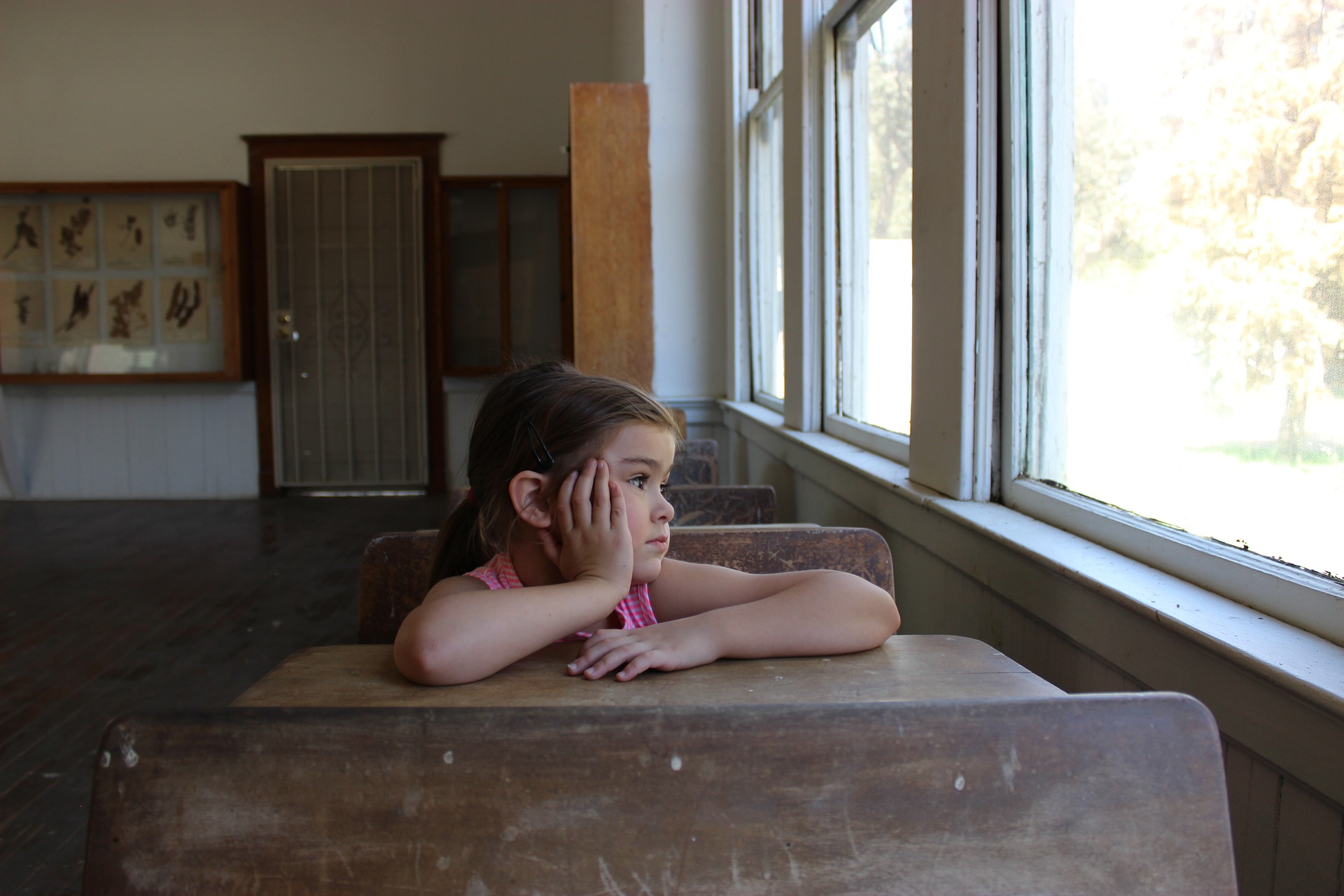 girl at desk looking out window